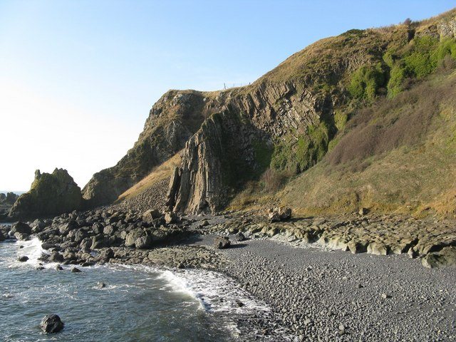 Stone beach beneath the basalt rock pillars of Kincraig Point at low tide