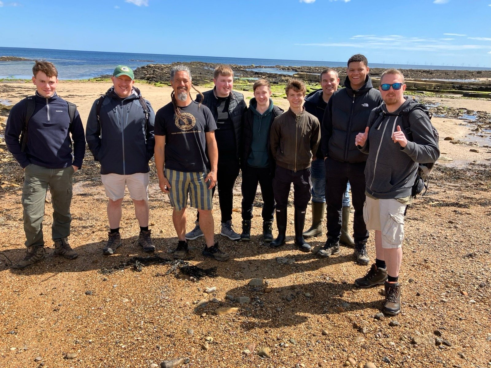 A private group of guests lined up on the beach after a workshop