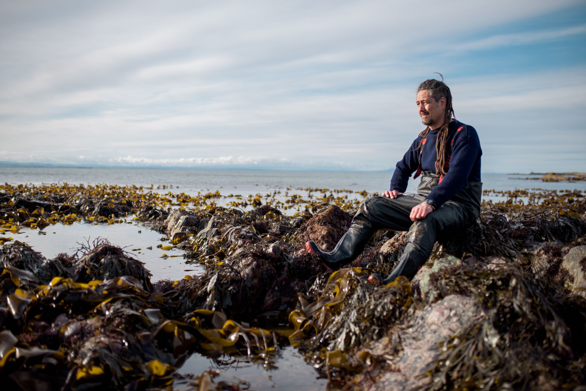 Jayson seated among the kelp beds in low winter sun