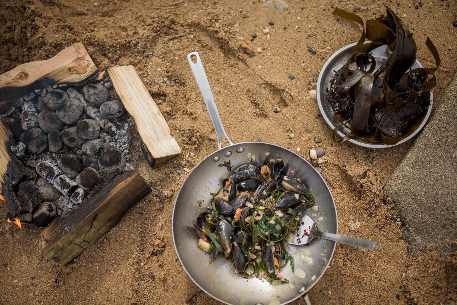 Mussels cooking over an open fire on the beach
