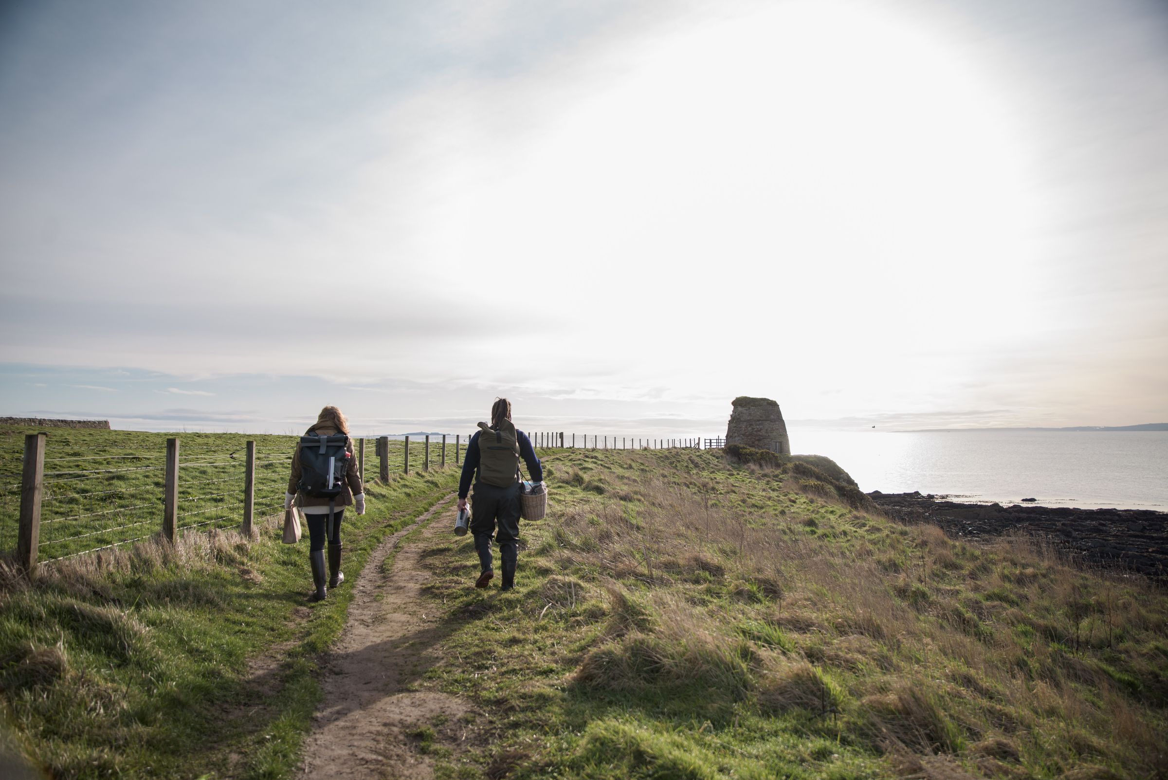 Walkers on the coastal path into the morning sun